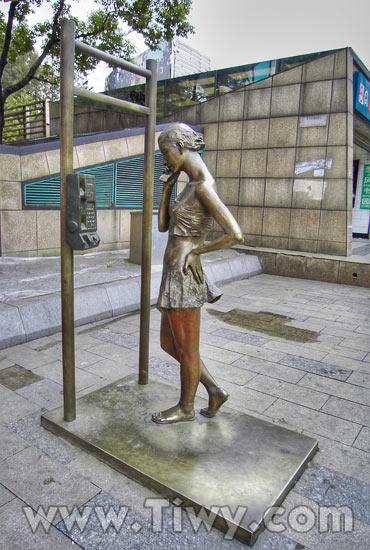 雕塑 — 一个女孩和一个电话亭。