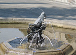 A cozy fountain with a bronze grasshopper who has comfortably settled down in its center