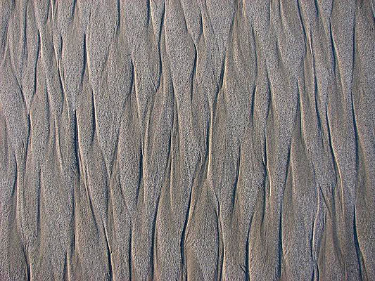 The rising tide left on the sand that resembles a Pacific wallpaper or screen for siren monitors
